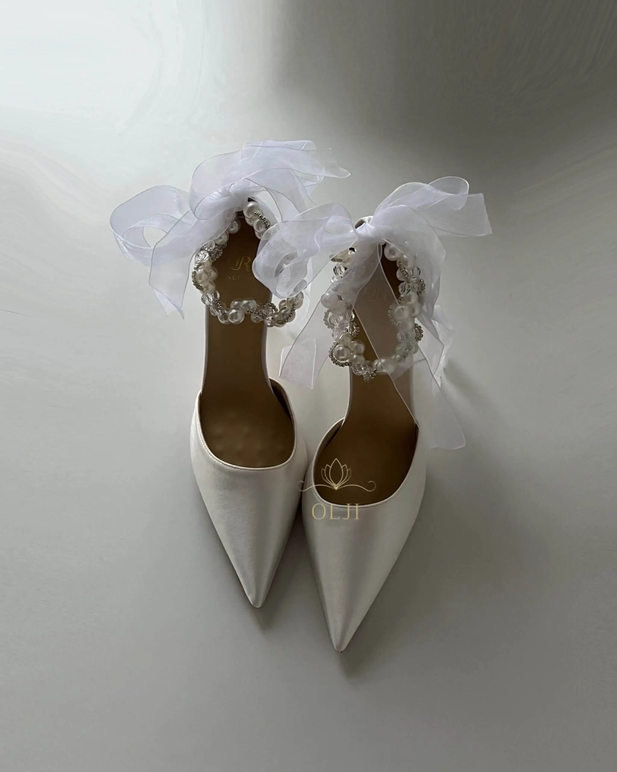 Білосніжні атласні туфлі з перлами та прозорим обʼємним бантом