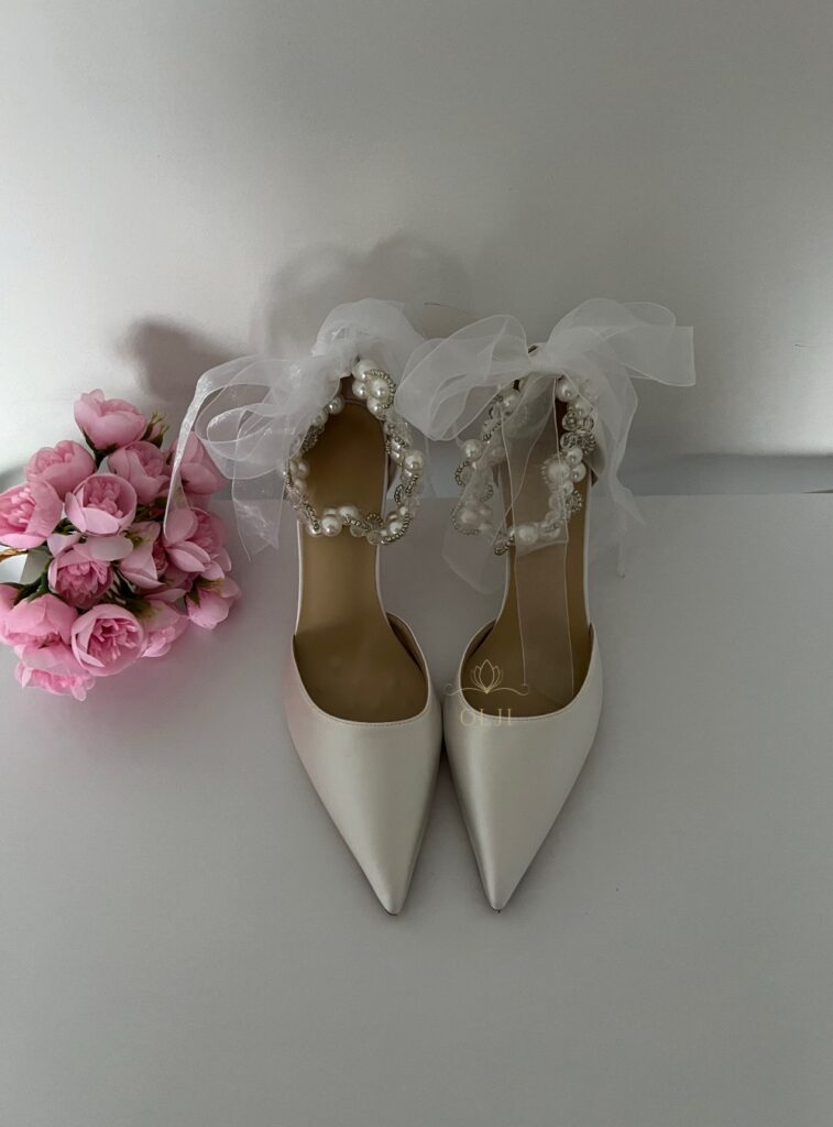 Білосніжні атласні туфлі з перлами та прозорим обʼємним бантом