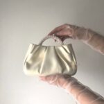 Шкіряна перламутрова сумочка з ручкою з перлин та шкіряним поясом