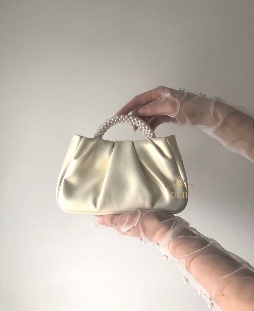 Шкіряна перламутрова сумочка з ручкою з перлин та шкіряним поясом