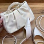 Шкіряна перламутрова сумочка з ручкою з перлин та шкіряним поясом