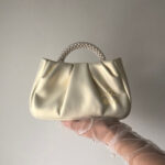 Шкіряна перламутрова сумочка з ручкою з перлин та шкіряним поясом