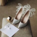 Блискучі туфлі з фатиновим бантом оздоблені дрібними перлами та блискітками